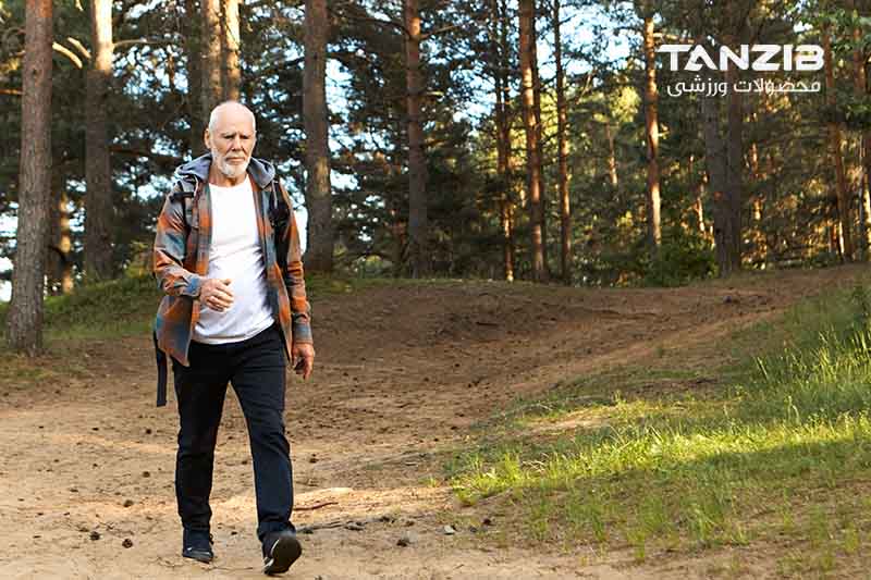 فردی در حال پیاده روی کردن در جنگل با کوله با لوگوی سفید تن زیب برای چه زمانی از روز برای پیاده روی بهتره