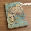 کتاب از کاپ تا کیپ رضا پاکروان روی میز چوبی