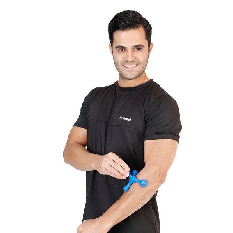 فردی در حال ماساژ دادن خود با ماساژور دستی بدن مدل ستاره ای در قسمت ساعد با لباس مشکی