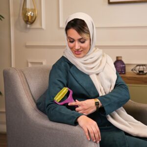 ماساژور دستی سوزنی در دست یک خانم خانه دار نشسته بر مبل