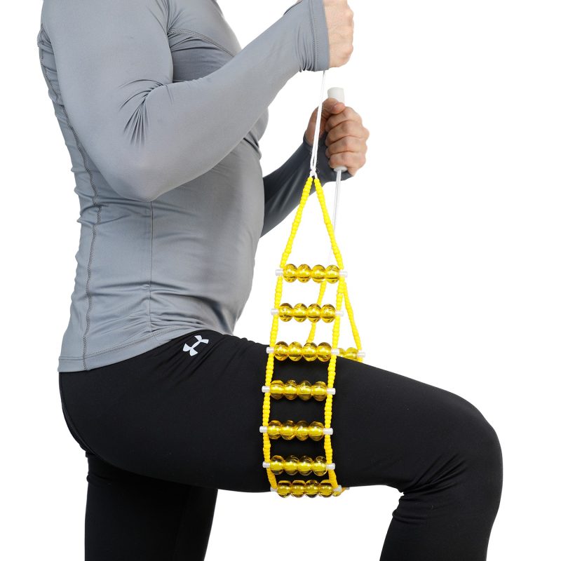 ماساژور کمر تن‌زیب مدل مهره‌ای زرد روی ران یک مدل با شلوار مشکی و بلوز طوسی