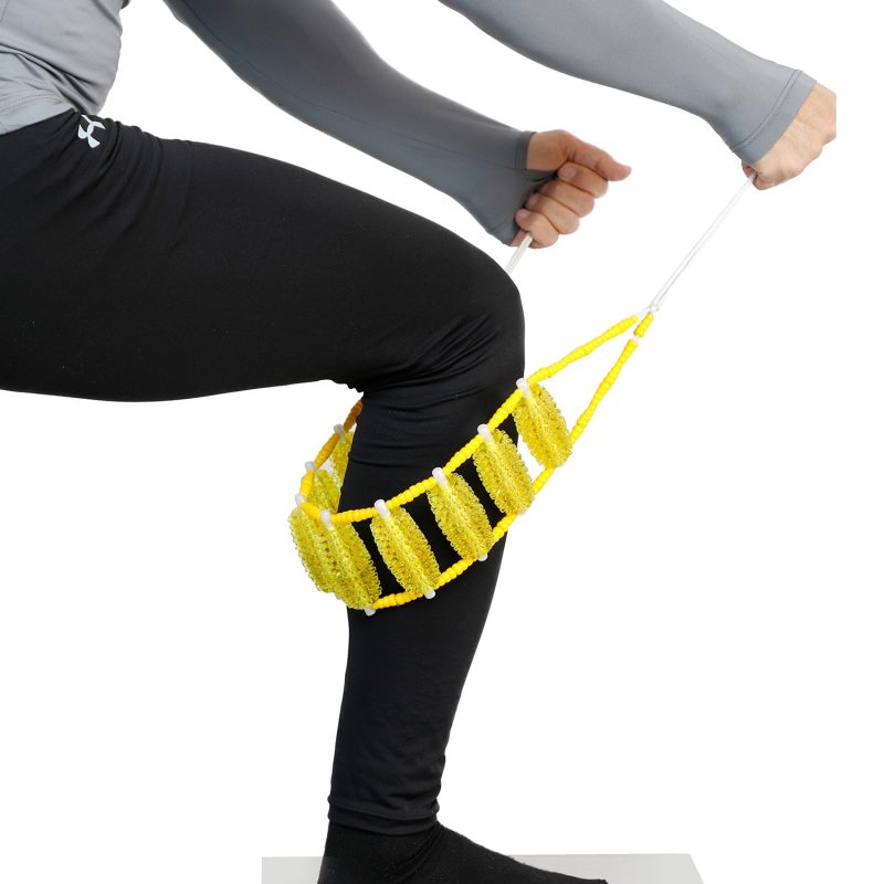 ماساژور کمر تن‌زیب مدل سوزنی زرد روی ساق پسری که در حال ماساژ دادن خود است