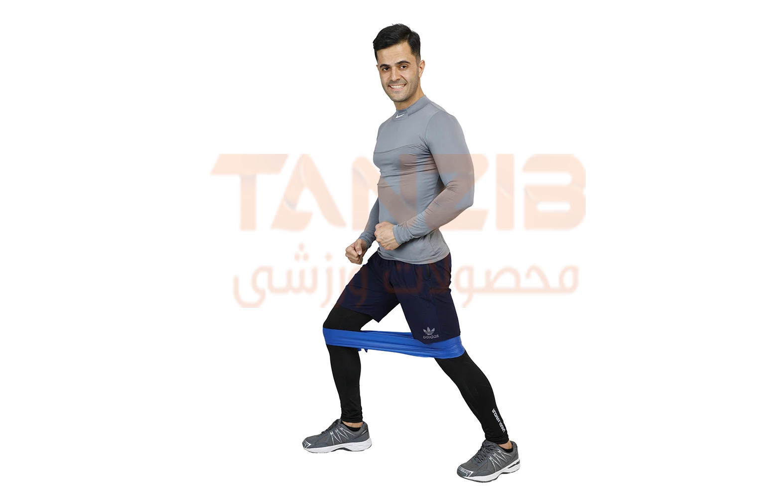 پسر ورزشکاری در حال تمرین با کش پیلاتس آبی